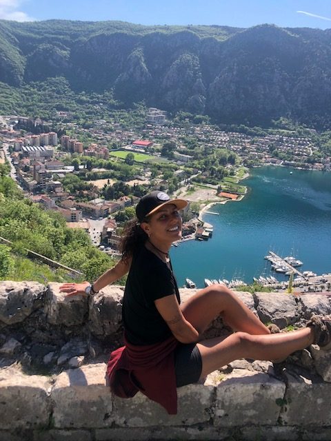 mulher em um mirante com vista panorâmica para uma cidade e um lago