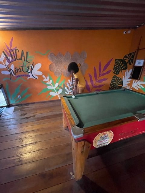 Ambiente com uma mesa de sinuca e paredes coloridas