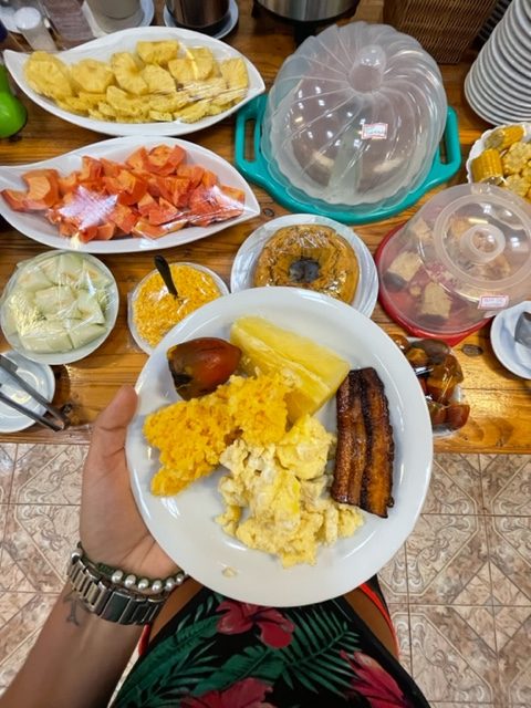 Uma mão segurando um prato com comidas de café da manhã típicas do Amazonas