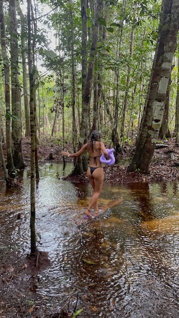 Mulher passando por um rio na natureza