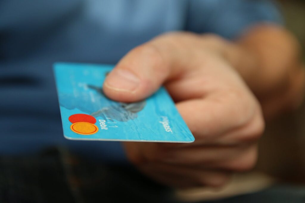 mão segurando um cartão de débito azul