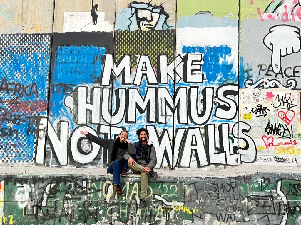 Muro com arte e duas pessoas em Belém, Palestina