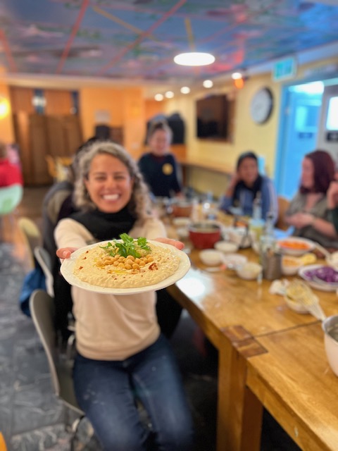 Mulher segurando um prato com Hummus no Workshop de Hummus