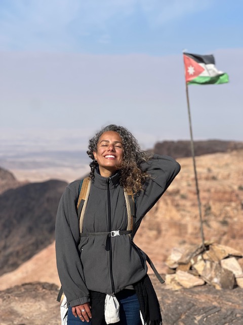 Mulher e a bandeira da Jordânia ao fundo