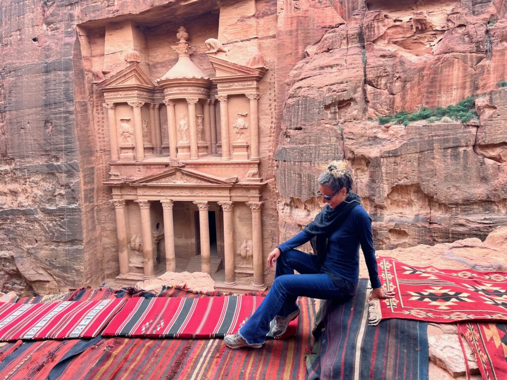 mulher sentada na frente de um monumento em Petra, em um roteiro pela Jordânia