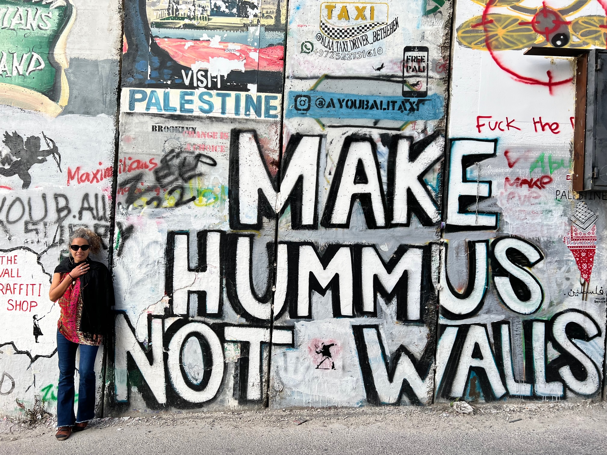 mulher no Muro de Separação em Belém, em uma viagem a Israel e Palestina