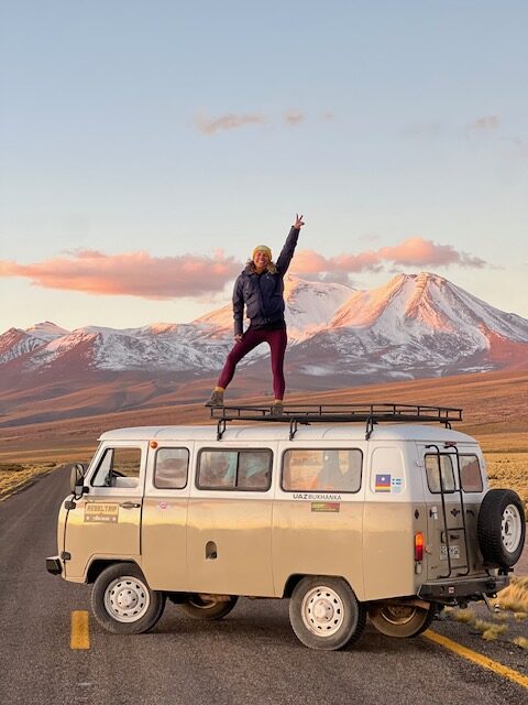 Mulher em cima de um kombi no deserto do Atacama