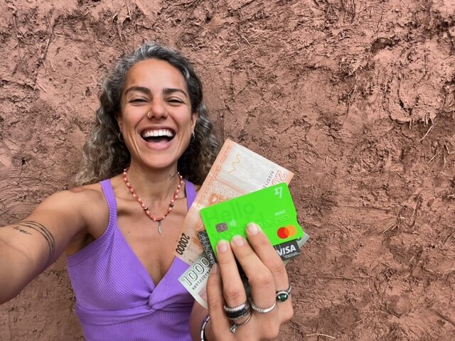 Mulher segurando dinheiro e cartão da Wise no Chile