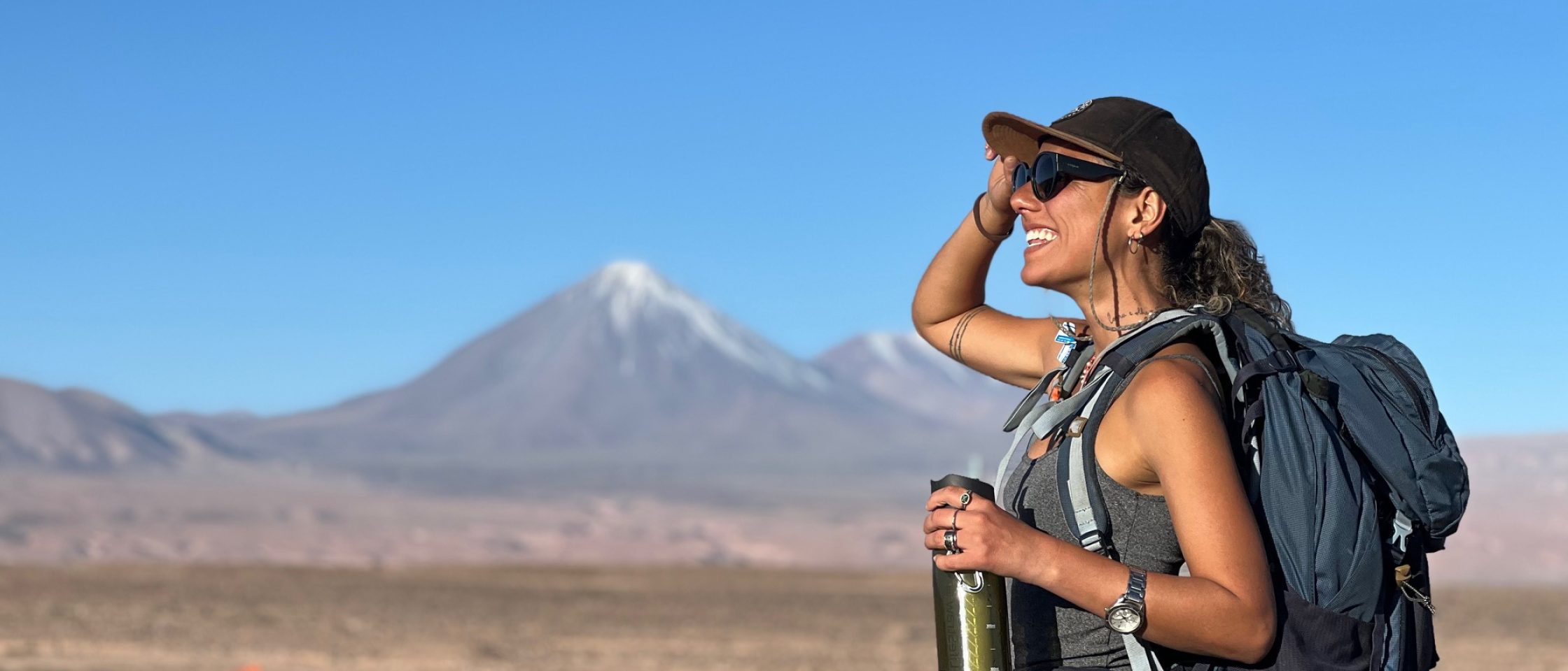mulher em um deserto viajando só com bagagem de mão